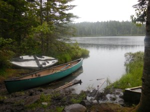 A typical Maine pond, complete with canoes ready for paddling hikers...